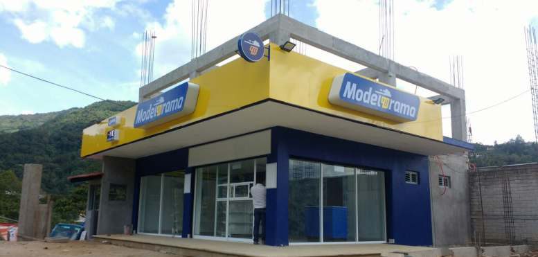 Modelorama: Fachada con anuncios luminosos y faldón de aluminio